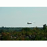 Photo Small Airplane Landing Over Woods Vehicle